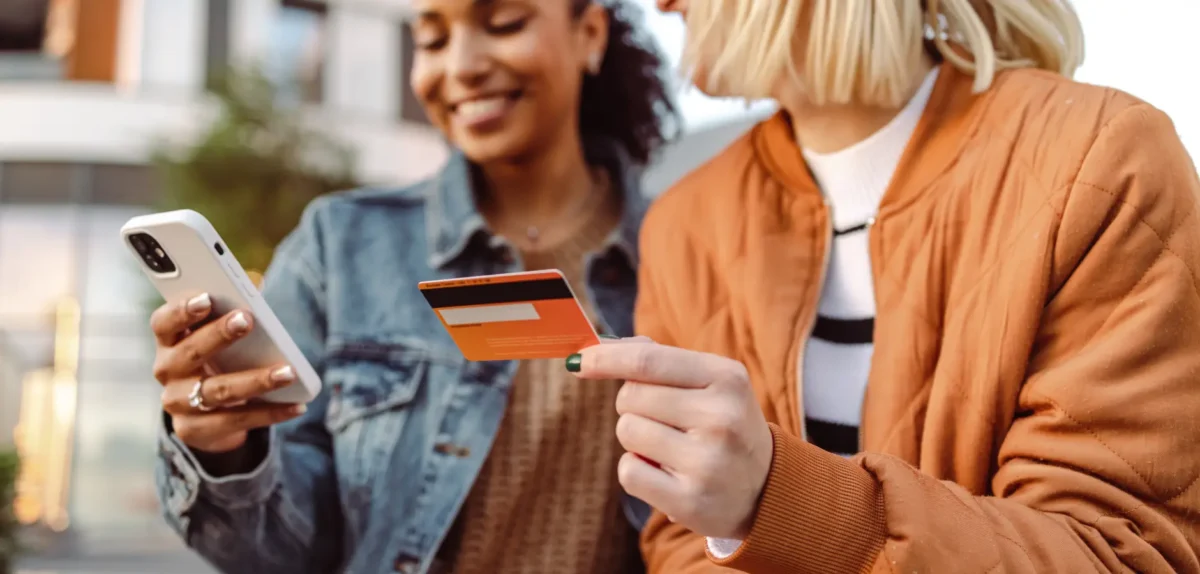 Two woman busy online shopping with mobile and credit card