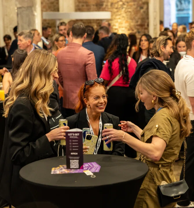 Attendees at a conference table conversing and sipping drinks, fostering collaboration and dialogue.