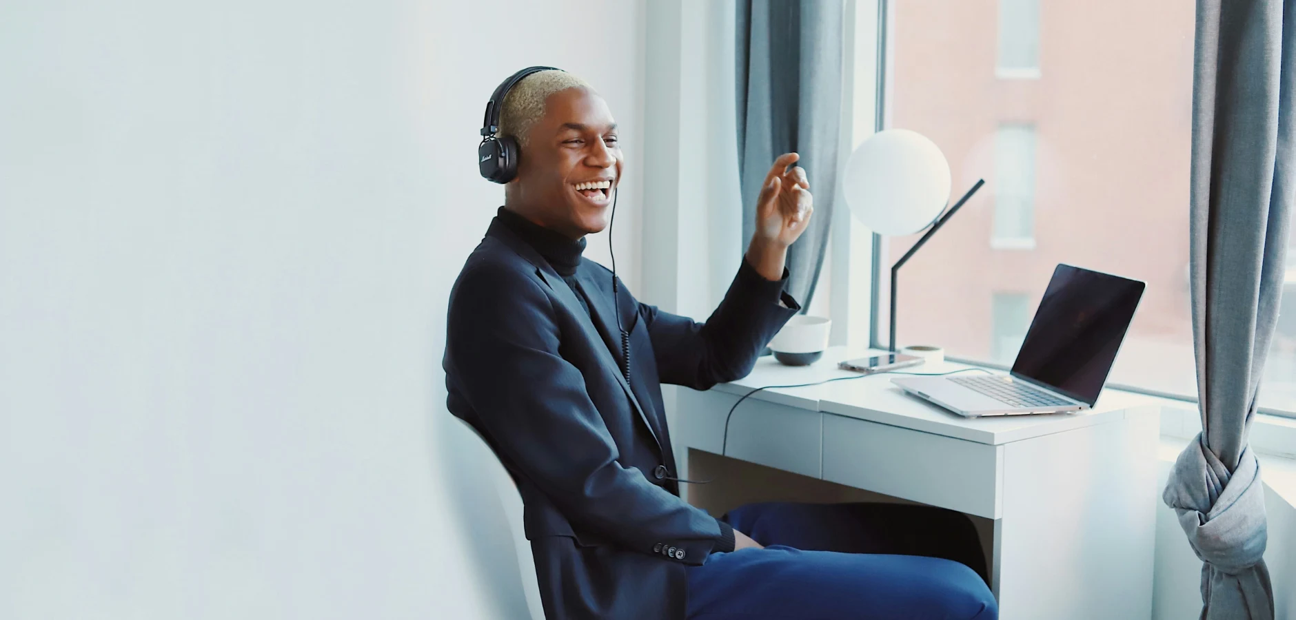 A man with headphones is seated at a desk, engaged in an activity that requires concentration.