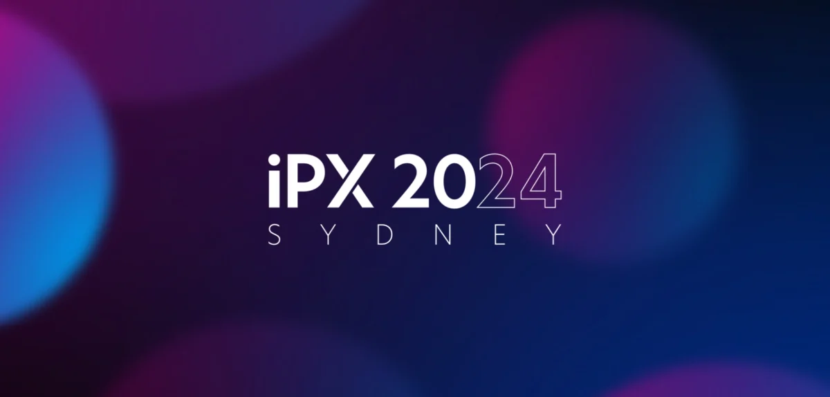 The Sydney skyline serves as a backdrop for the IPX 2024 event, highlighting the dynamic atmosphere of the conference.