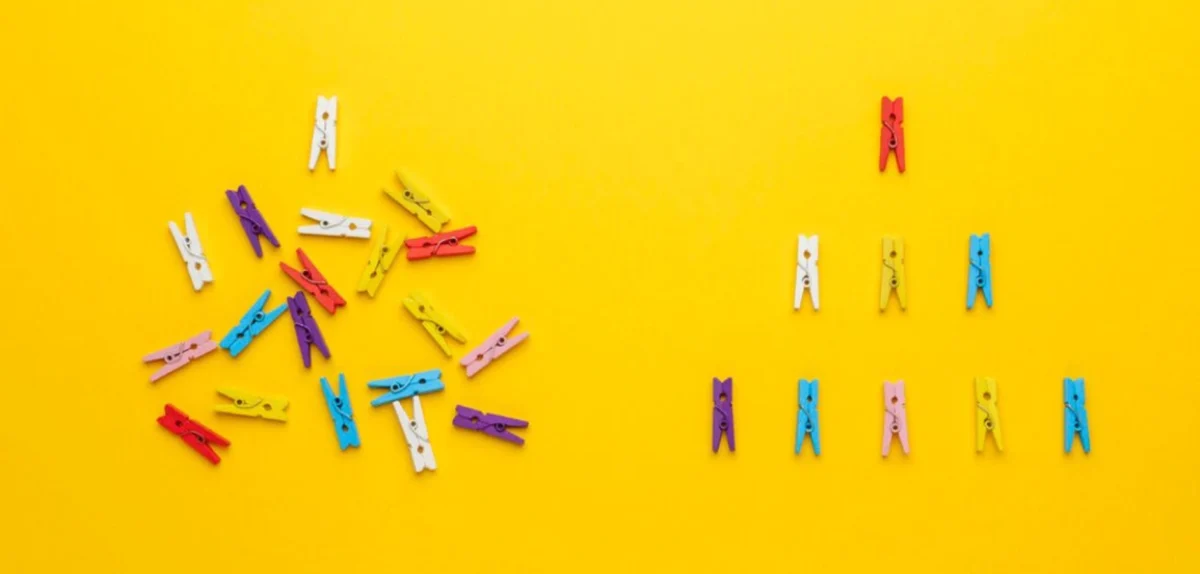 A vibrant array of clothespins in various colors set against a bright yellow background, showcasing additional clothespins on them.