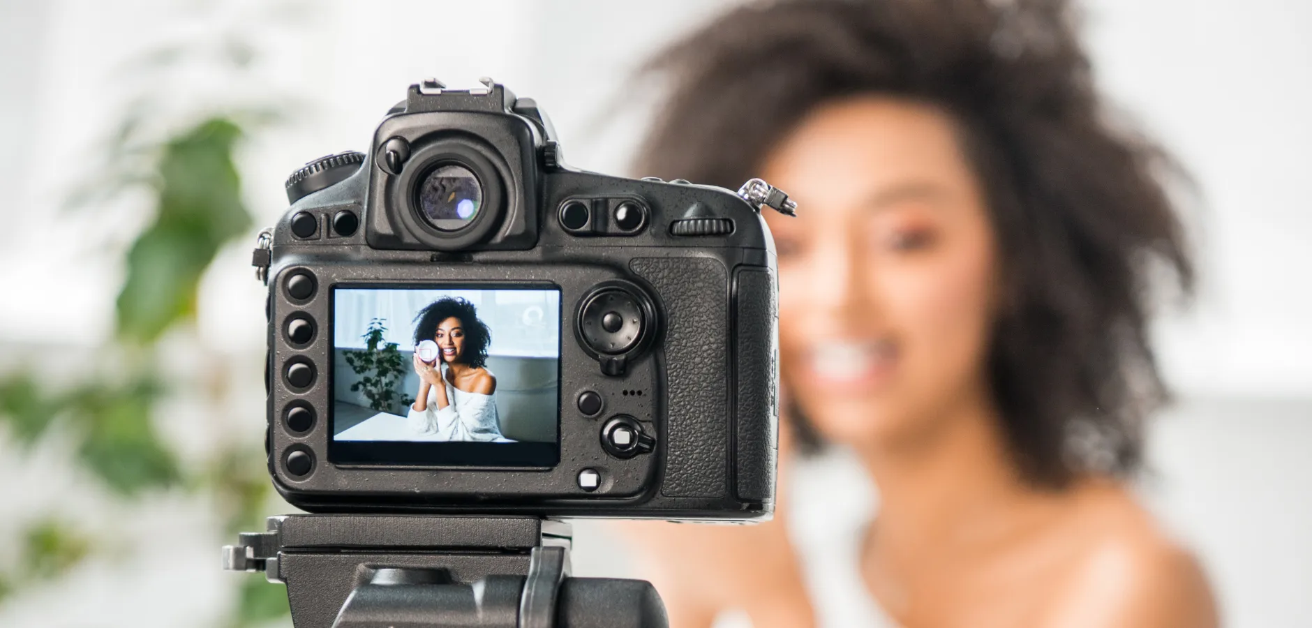 A woman recording a video with a camera, focused and engaged in her activity.