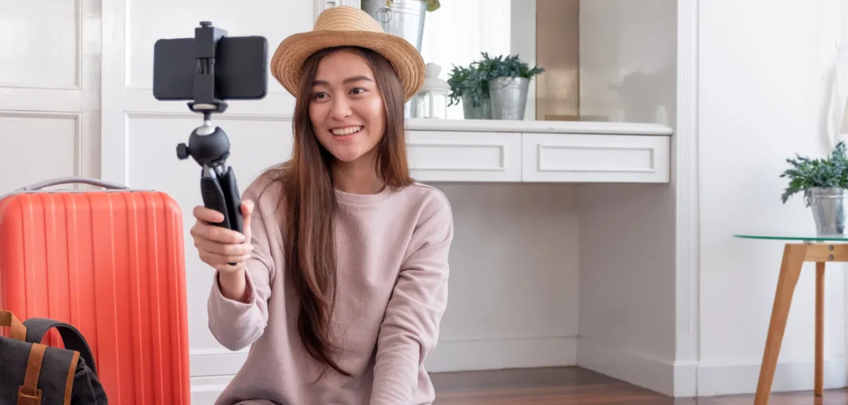 A woman smiles as she takes a selfie with her smartphone, capturing a moment of joy and self-expression.