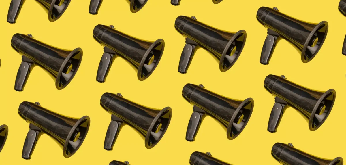 A repeating pattern of black megaphones on a vibrant yellow background.