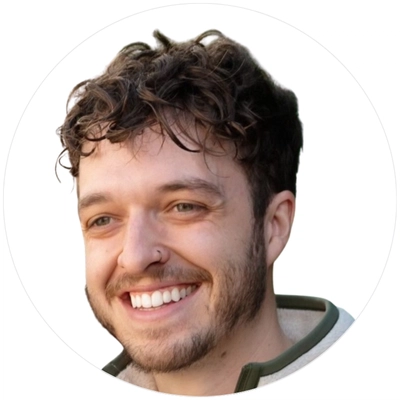 A young person with curly hair, wearing a light-colored sweater, set against a plain white background.