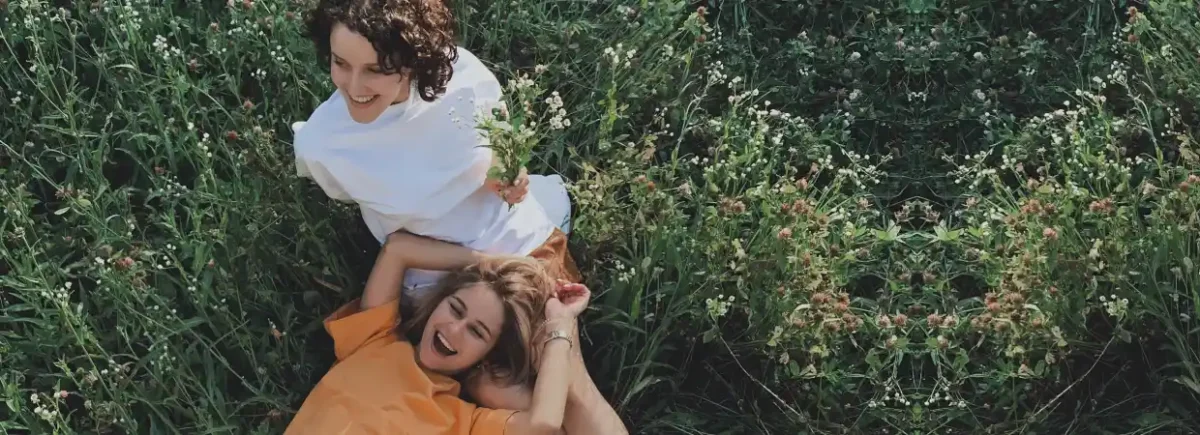 Two females lying down in tall grass