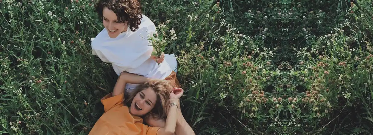 Two females lying down in tall grass