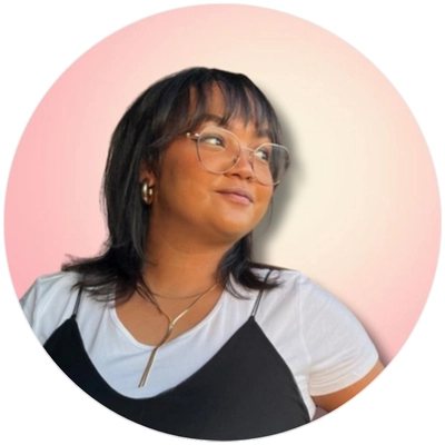 A woman wearing glasses and a black top gazes thoughtfully to the side.