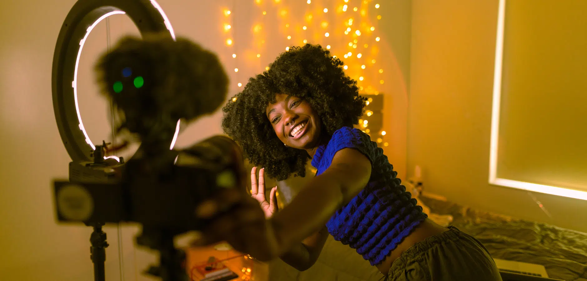A woman smiles while taking a selfie with a camera, capturing a moment of joy and self-expression.