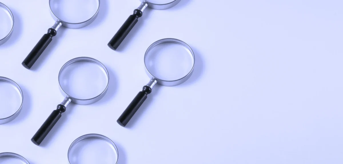 A collection of six magnifying glasses arranged on a white surface, showcasing their varying sizes and designs.
