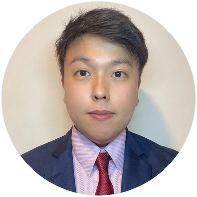 A young man in a suit and tie, confidently looking at the camera with a neutral expression.