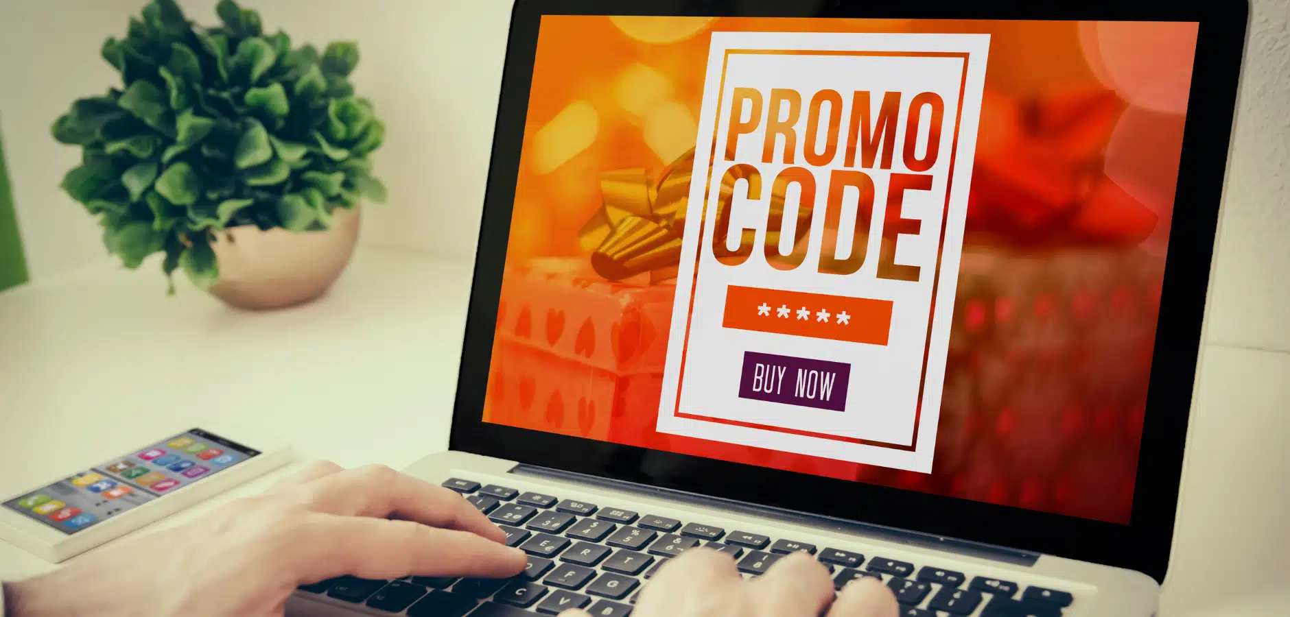 A person's hand typing on a laptop displaying a "Promo Code" advertisement, with a festive background and a potted plant nearby.