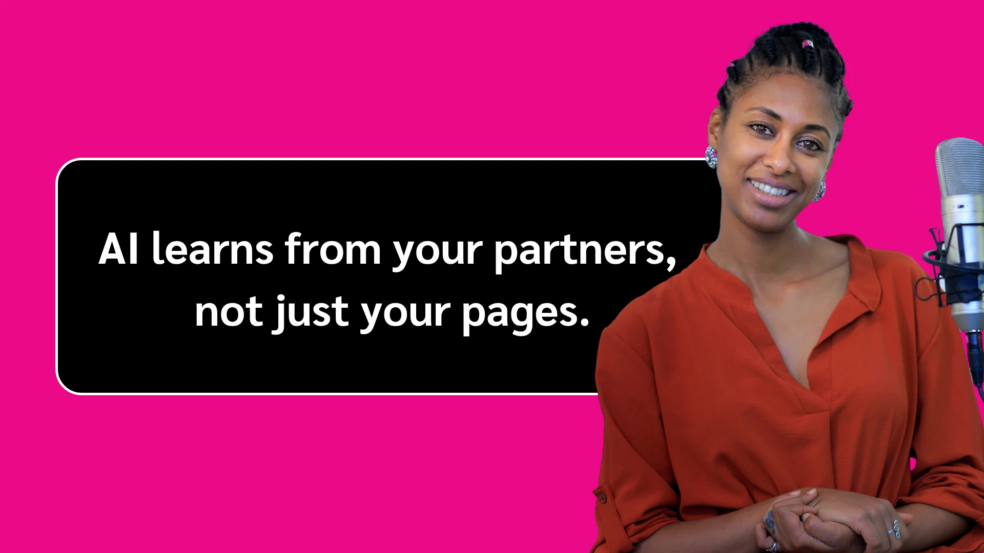 Person in red shirt standing by a microphone with text: "AI learns from your partners, not just your pages" on a pink background.