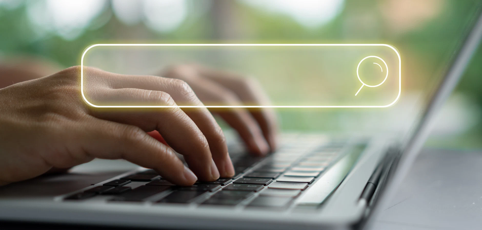Hands typing on a laptop keyboard with a translucent search bar and magnifying glass icon overlay.
