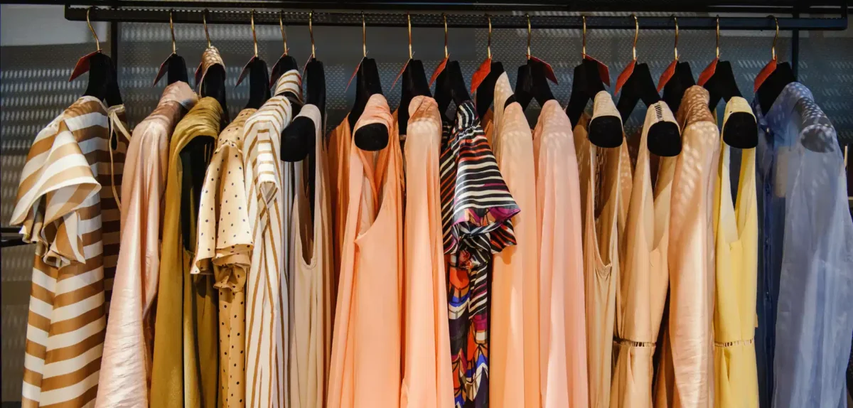A rack displaying a variety of colorful dresses in different styles and patterns, showcasing vibrant hues.