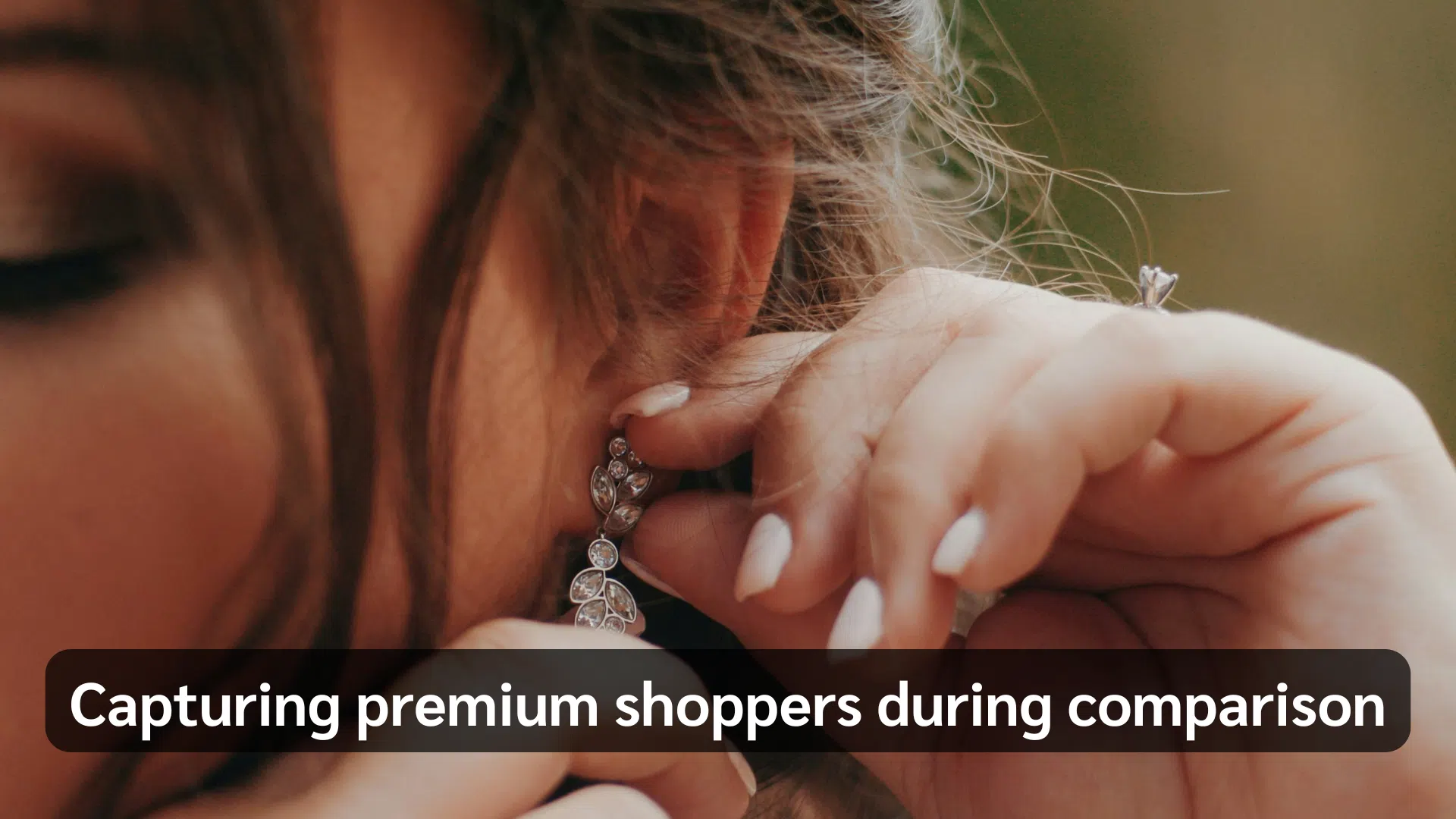 Close-up of a woman examining a diamond earring while wearing an engagement ring. Text reads, “Capturing premium shoppers during comparison.”